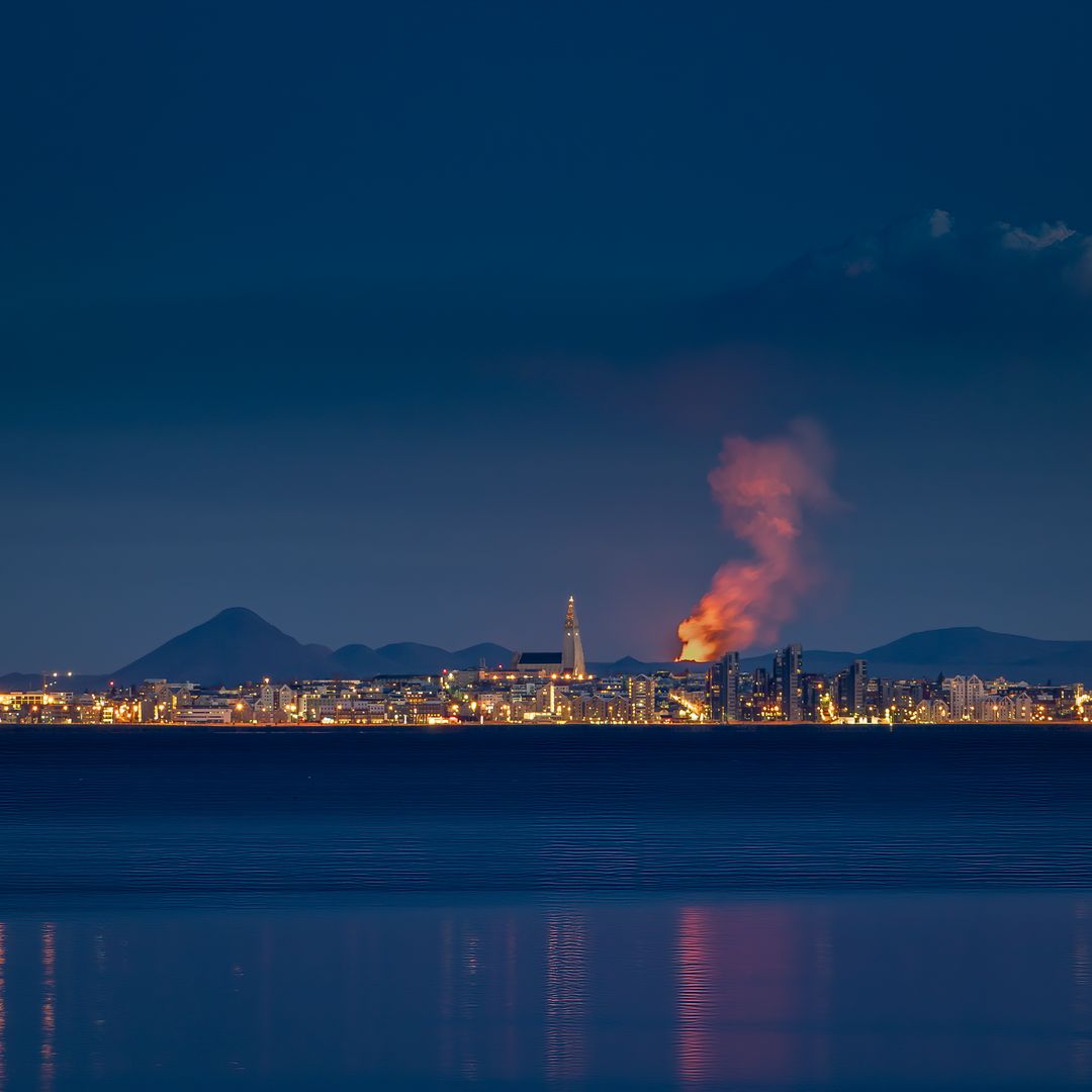 Skyline of Reykjavik with volcano eruption in background