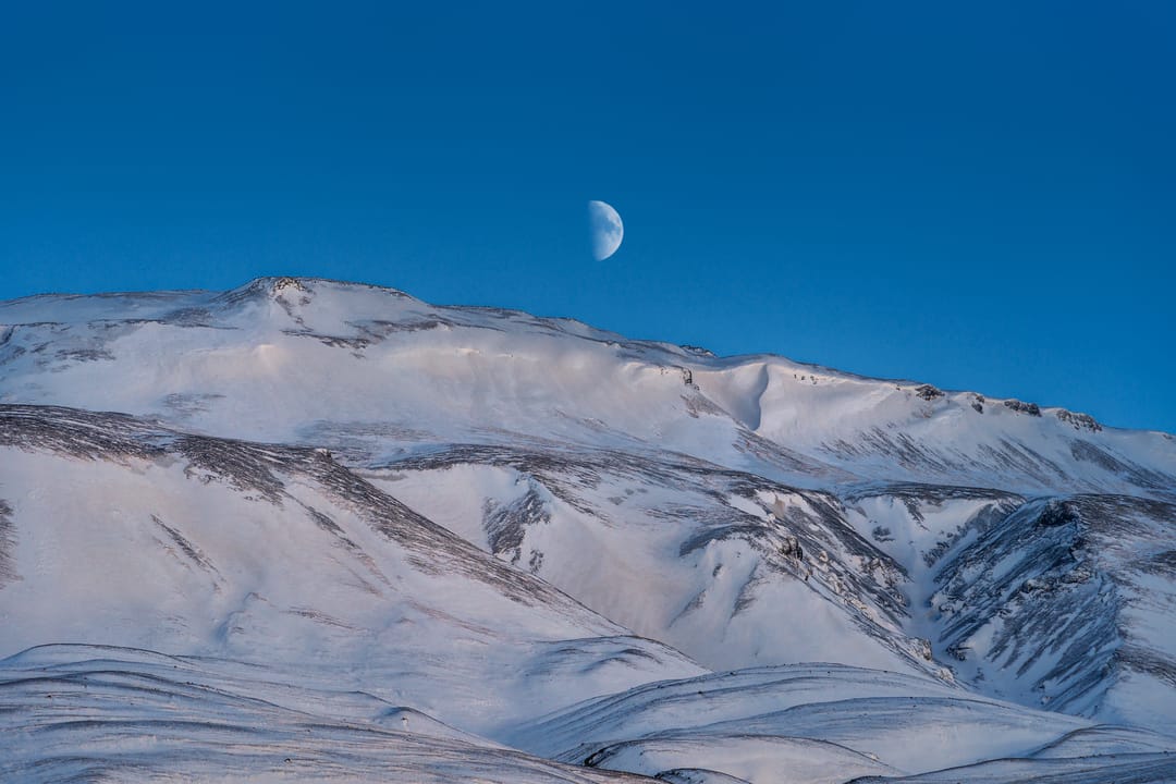 þórólfsfell covered in snow with the moon in the background