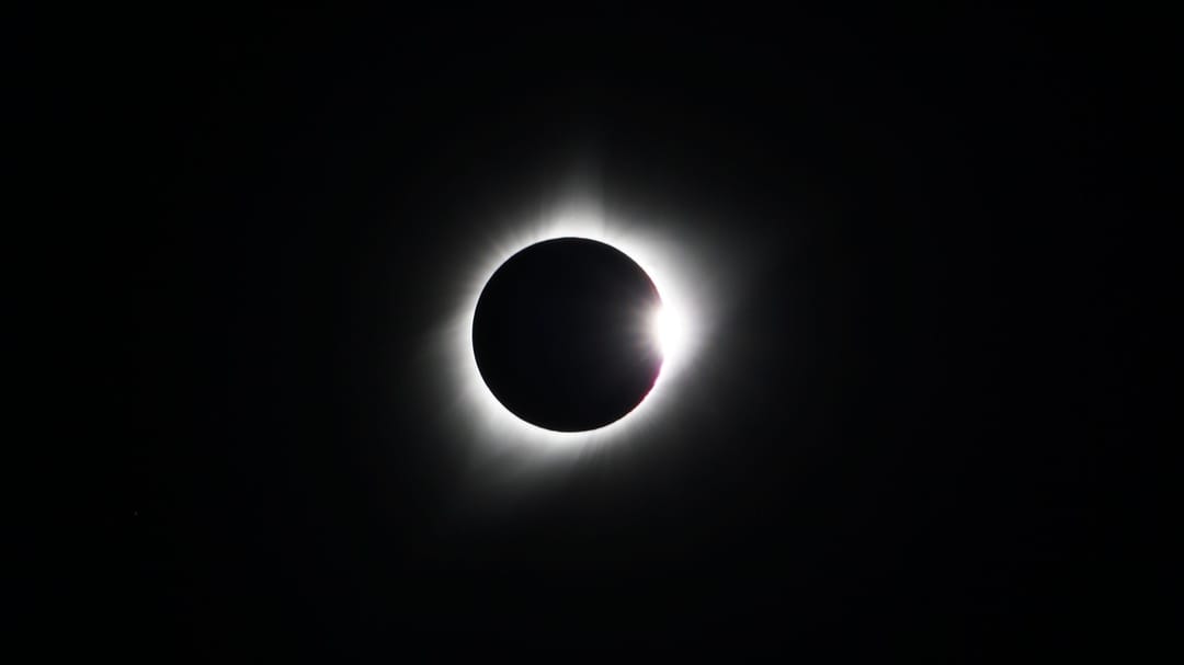 total solar eclipse with a white glow on a black background