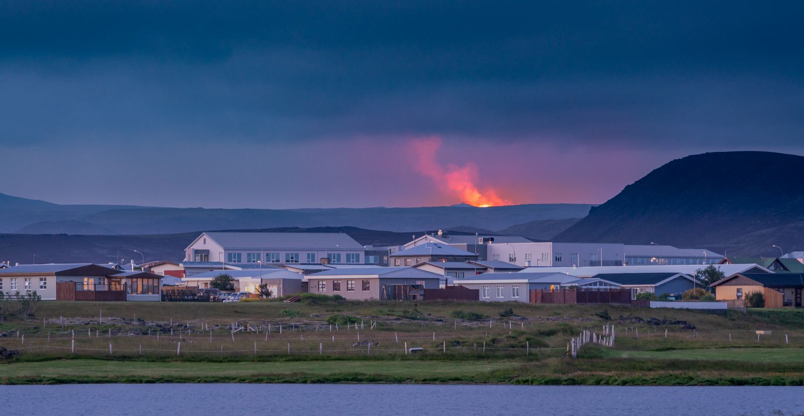 Grindavík with a volcanic eruption in the distance