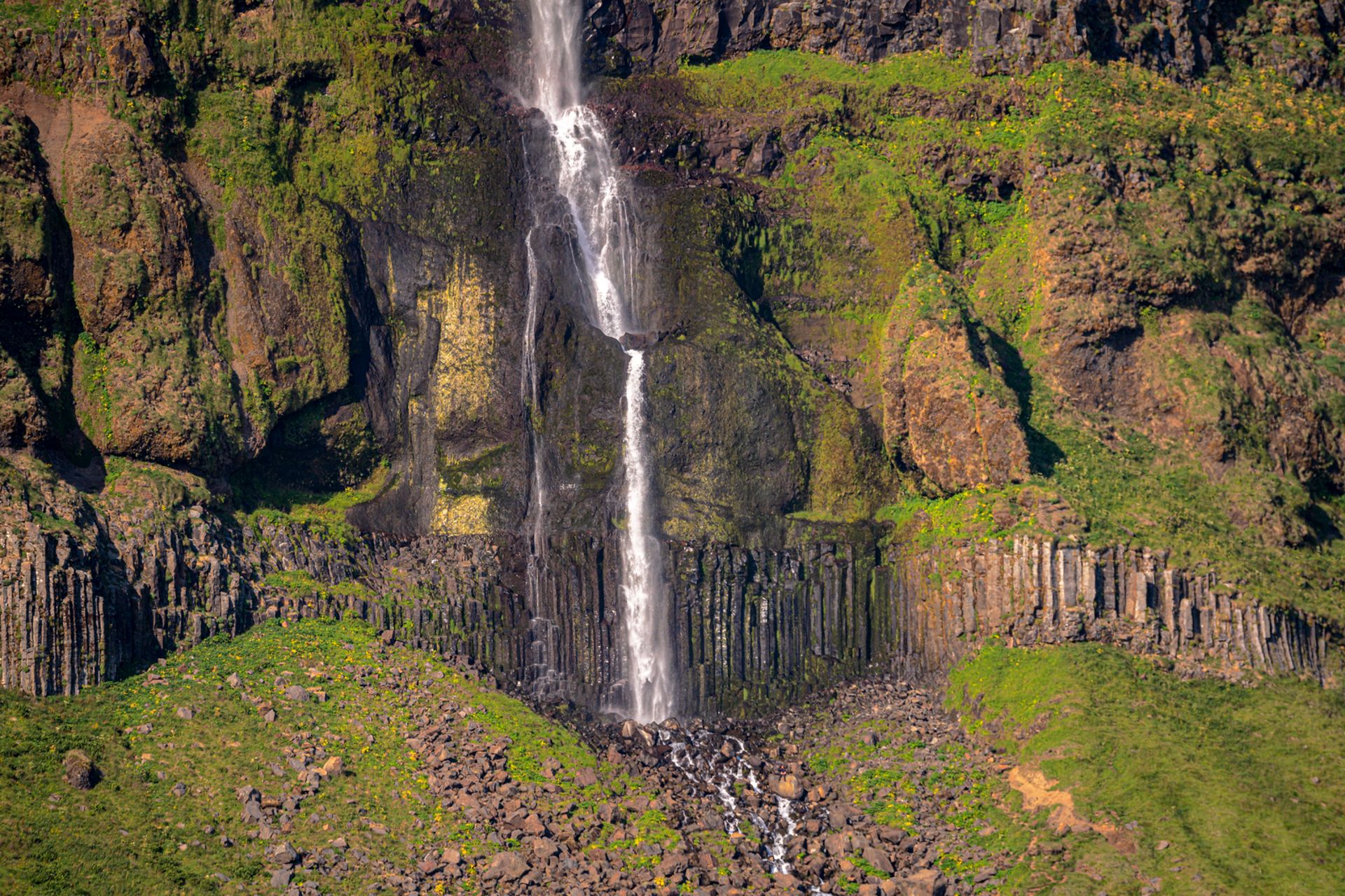 basalt columns with water falling over them