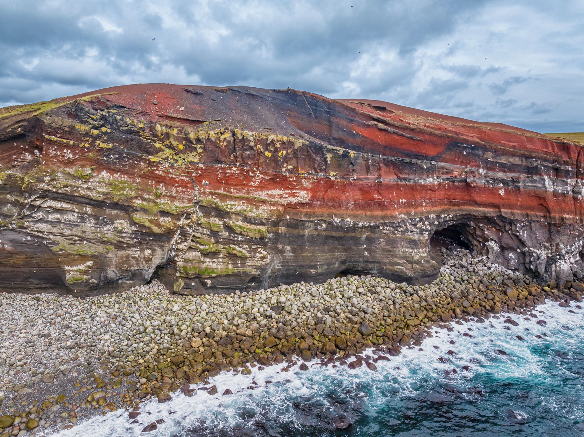 A red cliff and cave in Krýsuvík