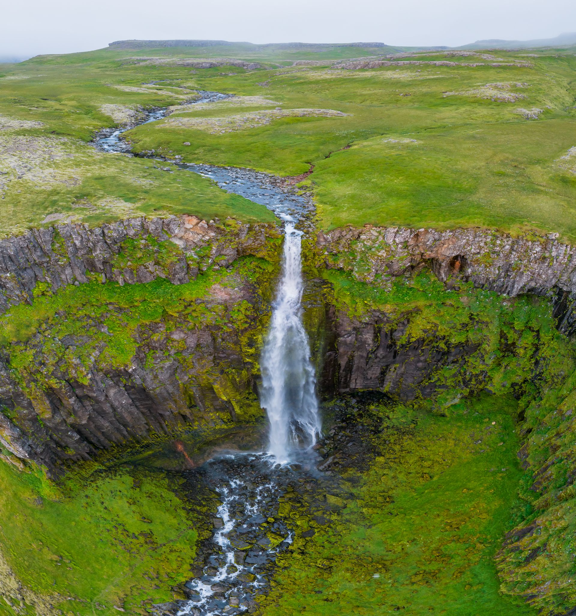 An aerial view of Svöðufoss with greenery all around