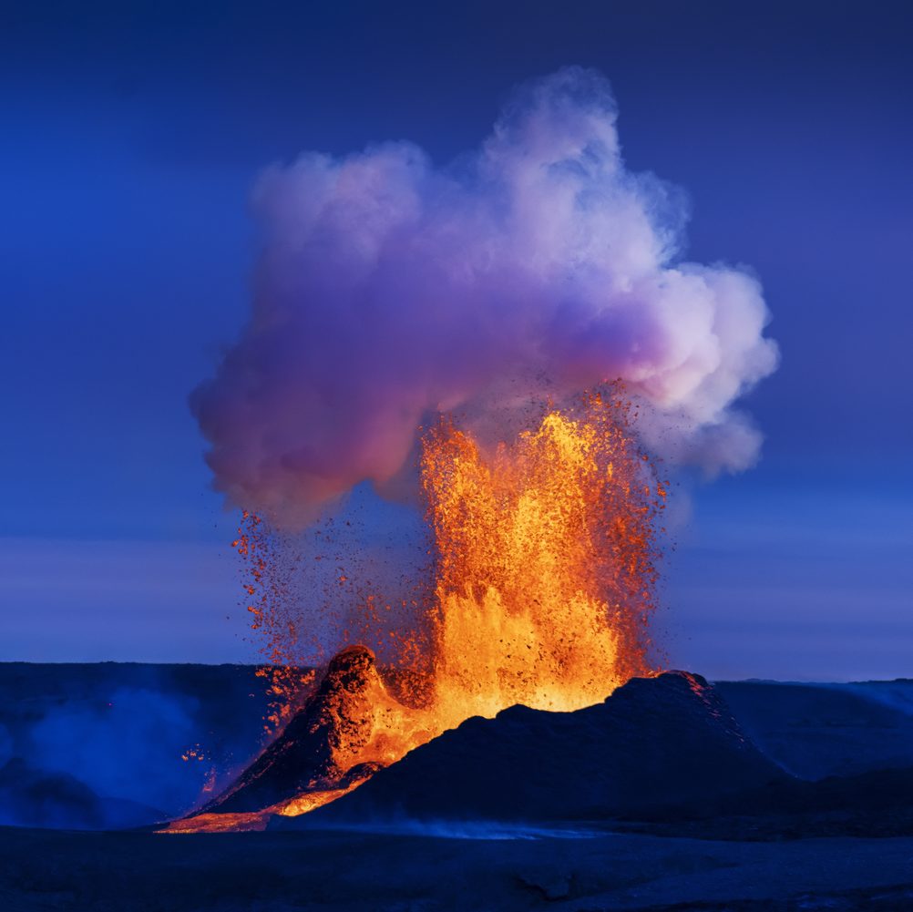 Lava erupting at Fagradalsfjall beneath a blue sky