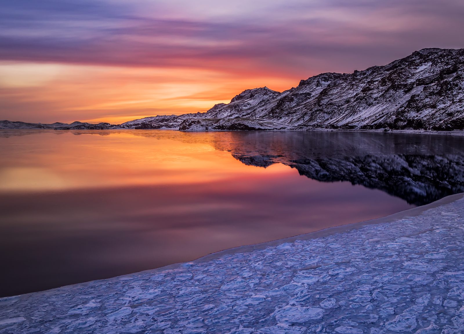 Kleifarvatn Lake at sunset, with dark volcanic ridges around the water
