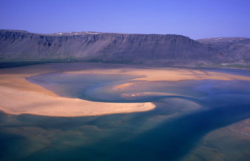 Aerial view of rauðasandur with a mountain in the background at dusk