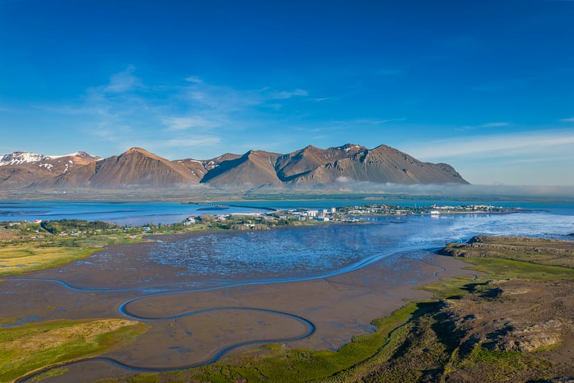 a coastal city in iceland with mountains in the background