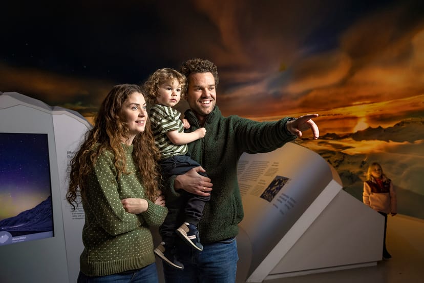 family with dad pointing in the glacier exhibit