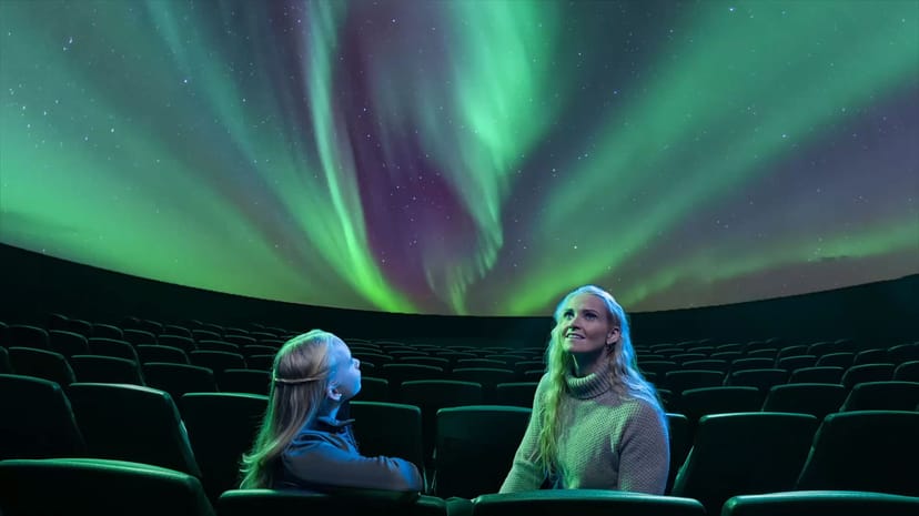 a mom and daughter watching the northern lights show in Reykjavík